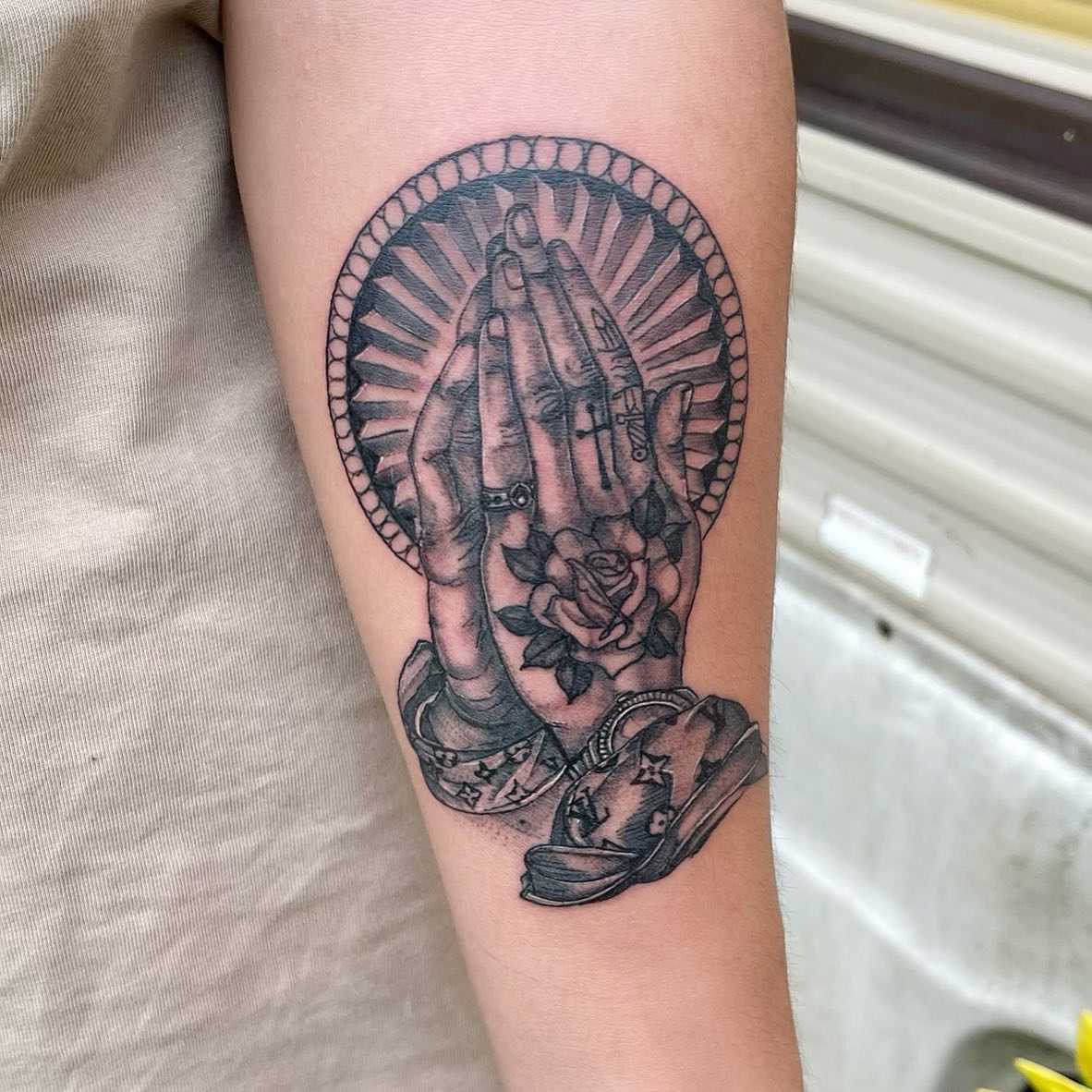 Tatuaje de Manos Orando en el Brazo