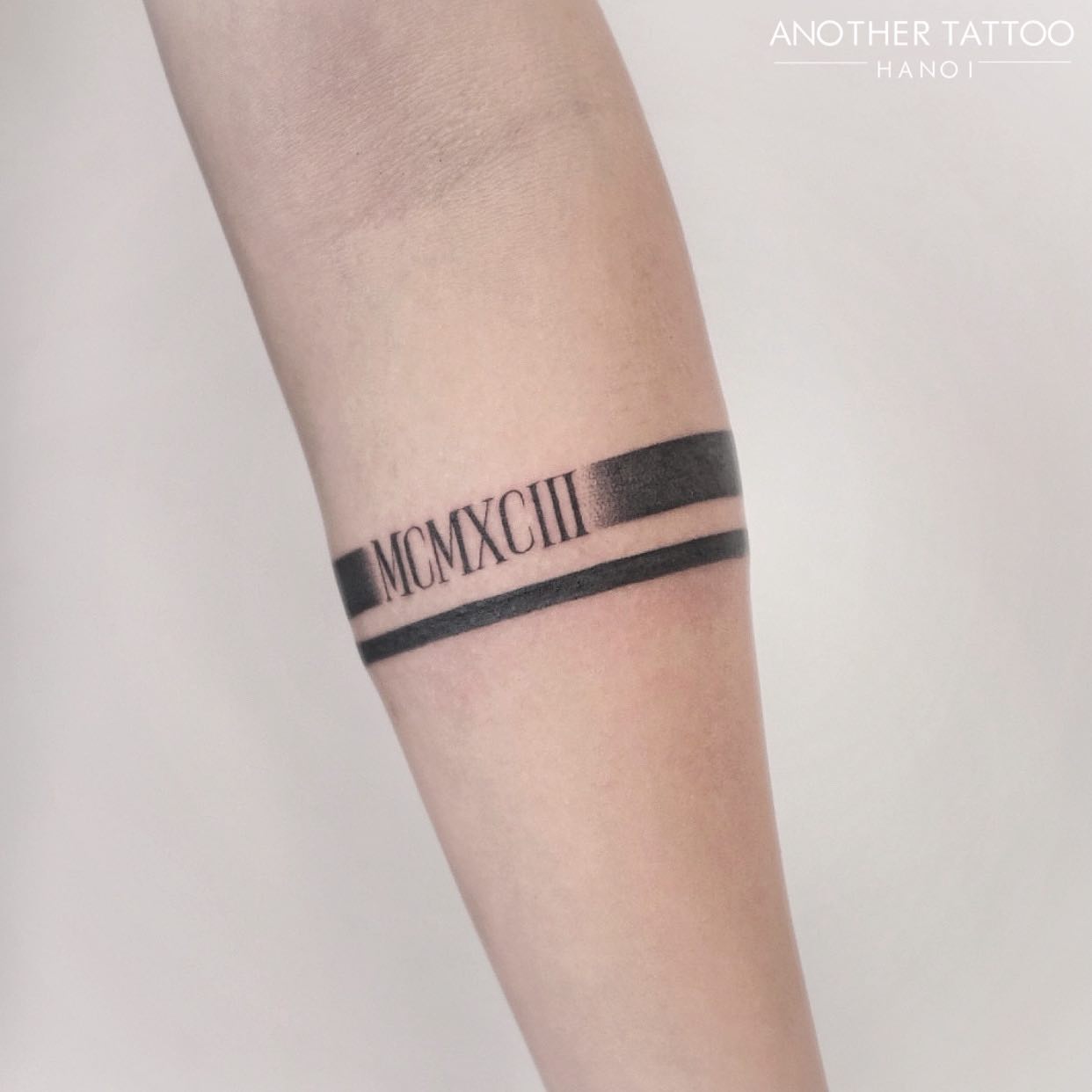 Tatuaje de números romanos contorneados en negro