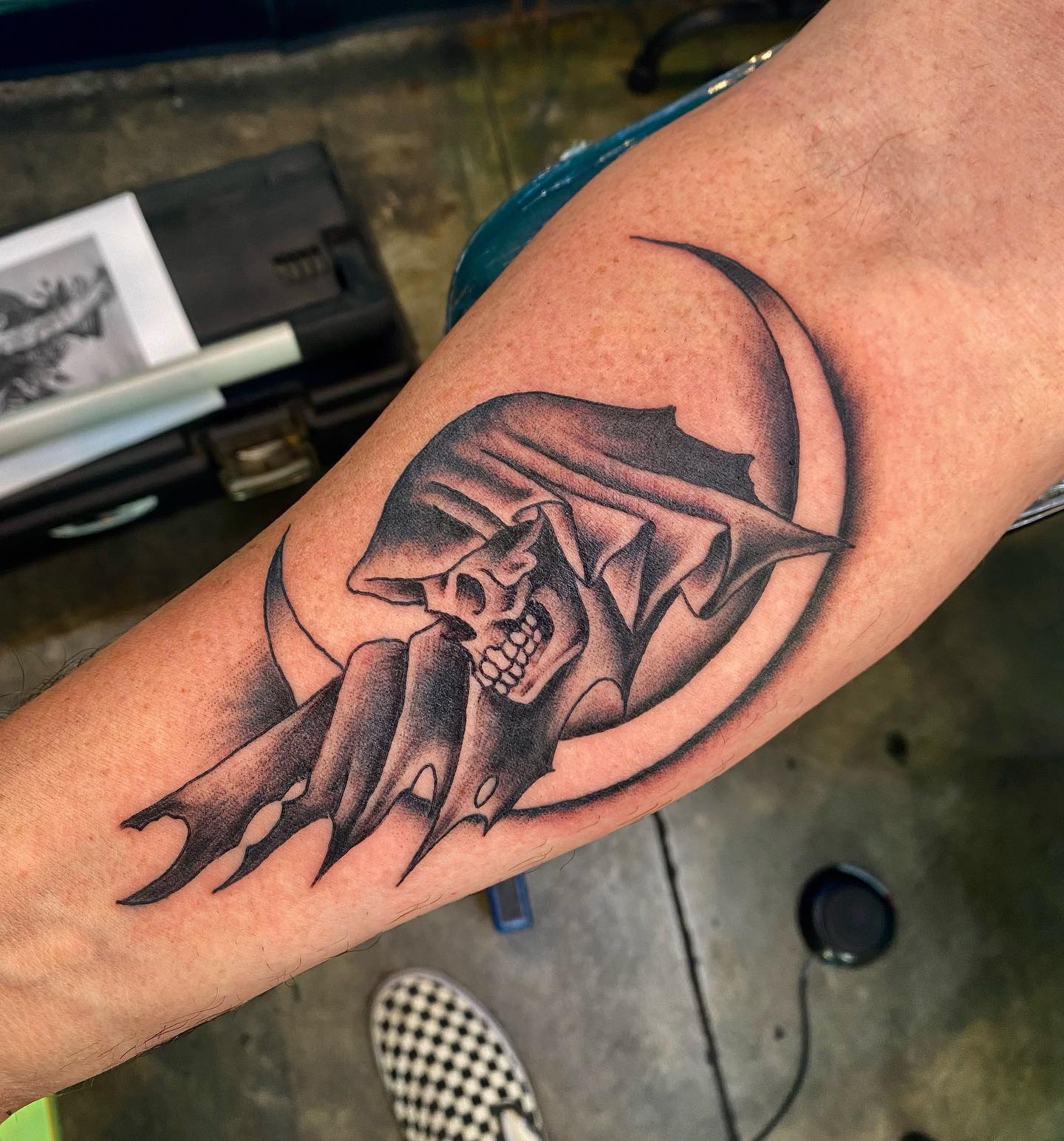 Tatuaje del Segador sombrío con contorno negro.