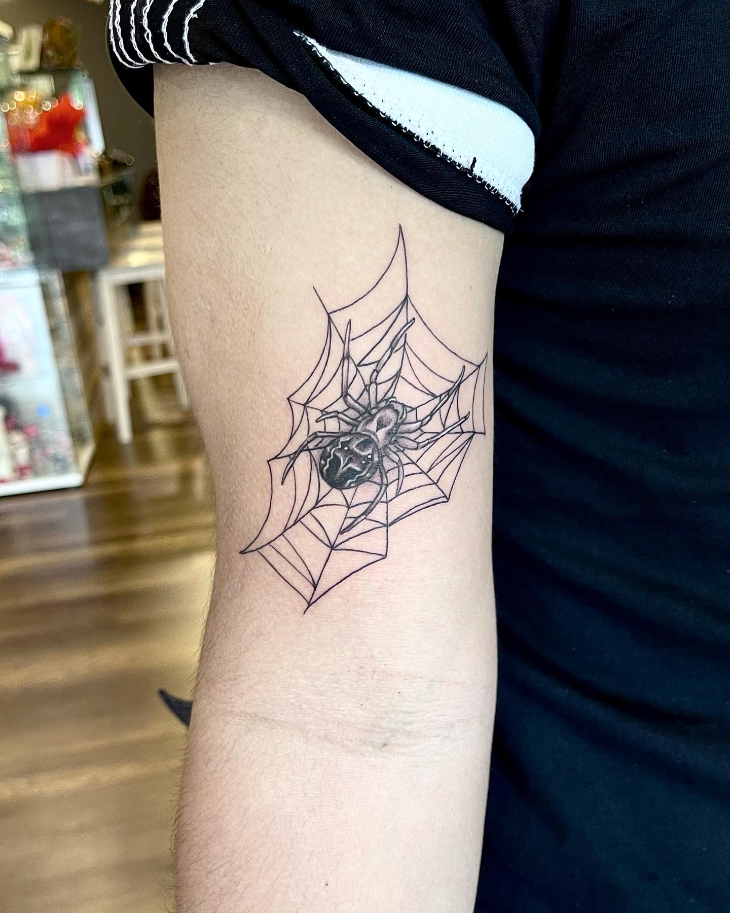 Tatuaje de tela de araña detallado y artístico.