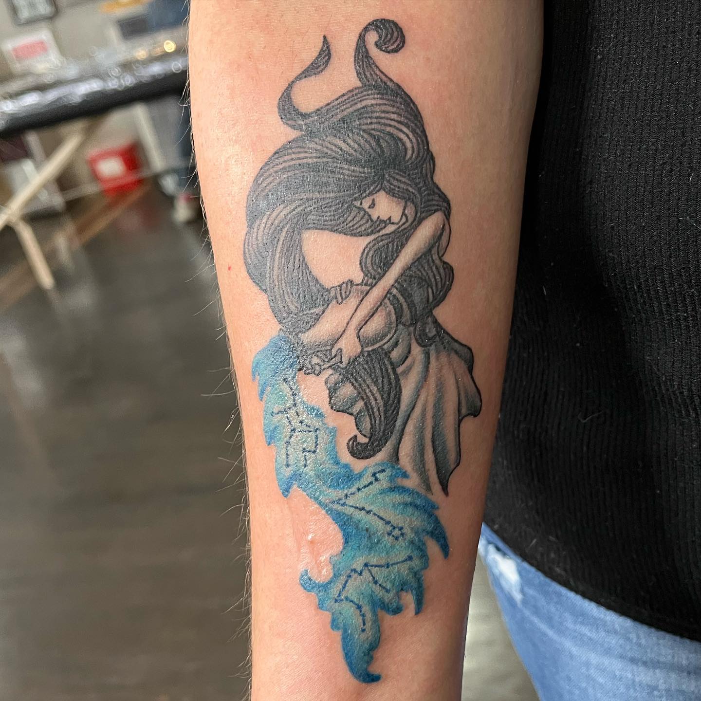 Diseño de tatuaje de Acuario en el brazo.