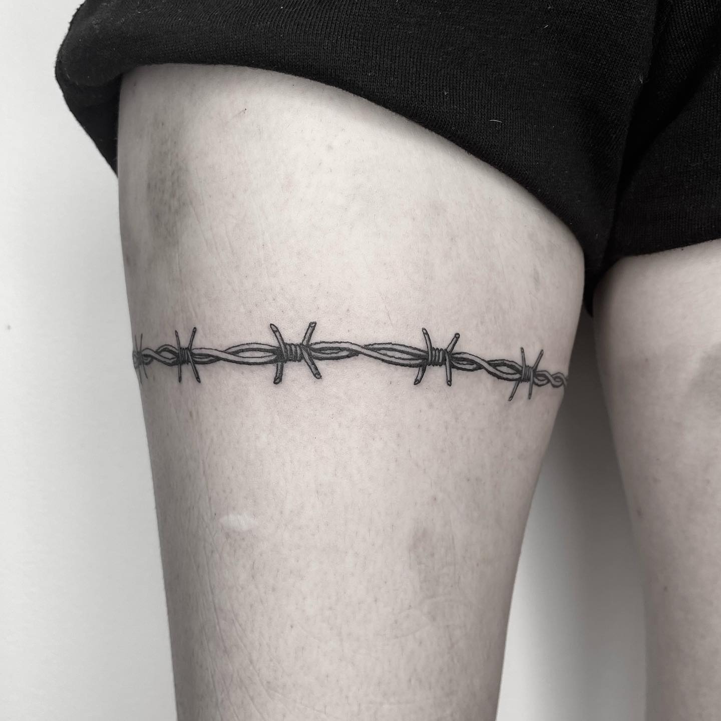 Tatuaje de alambre de púas en el muslo