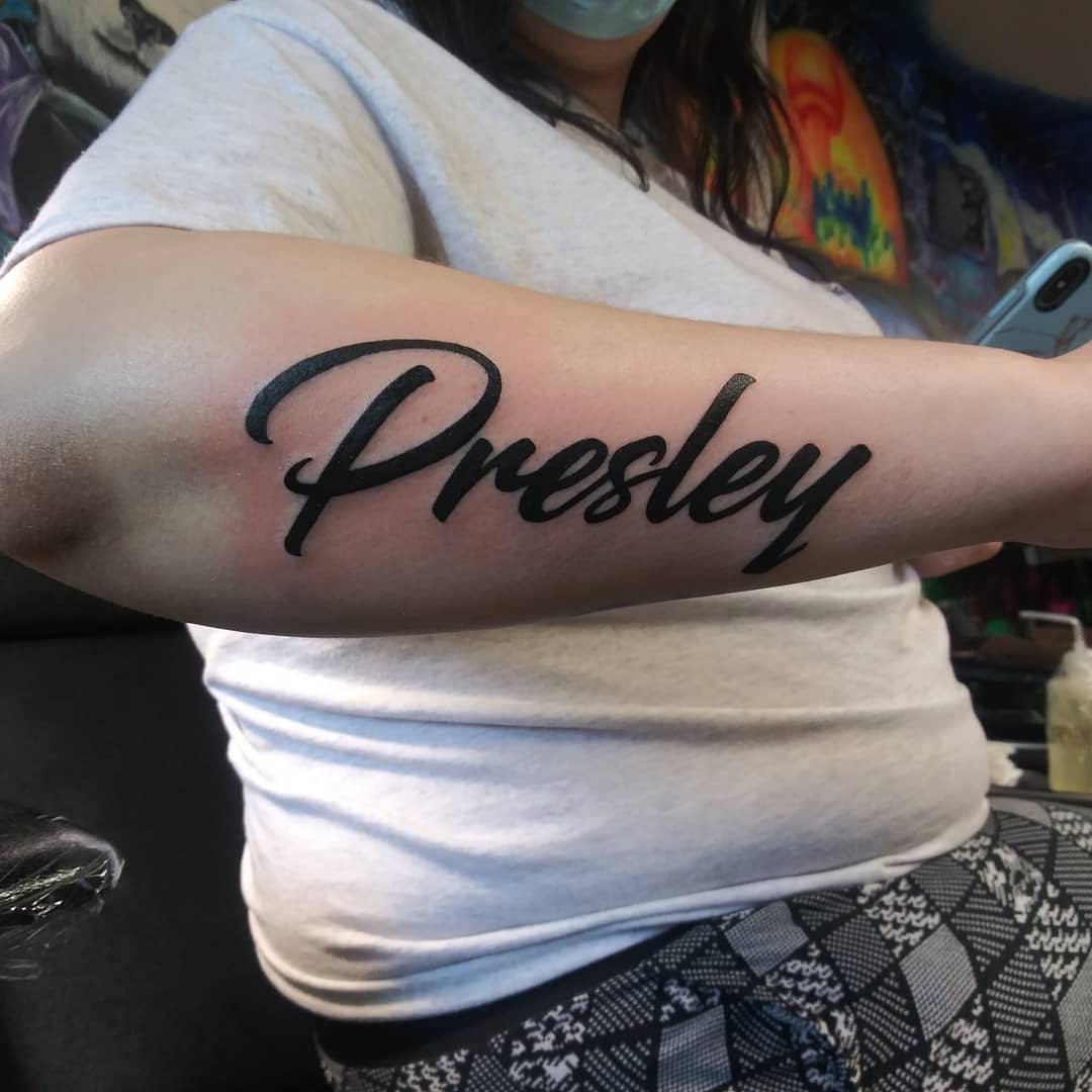Tatuaje del nombre del niño en el brazo.
