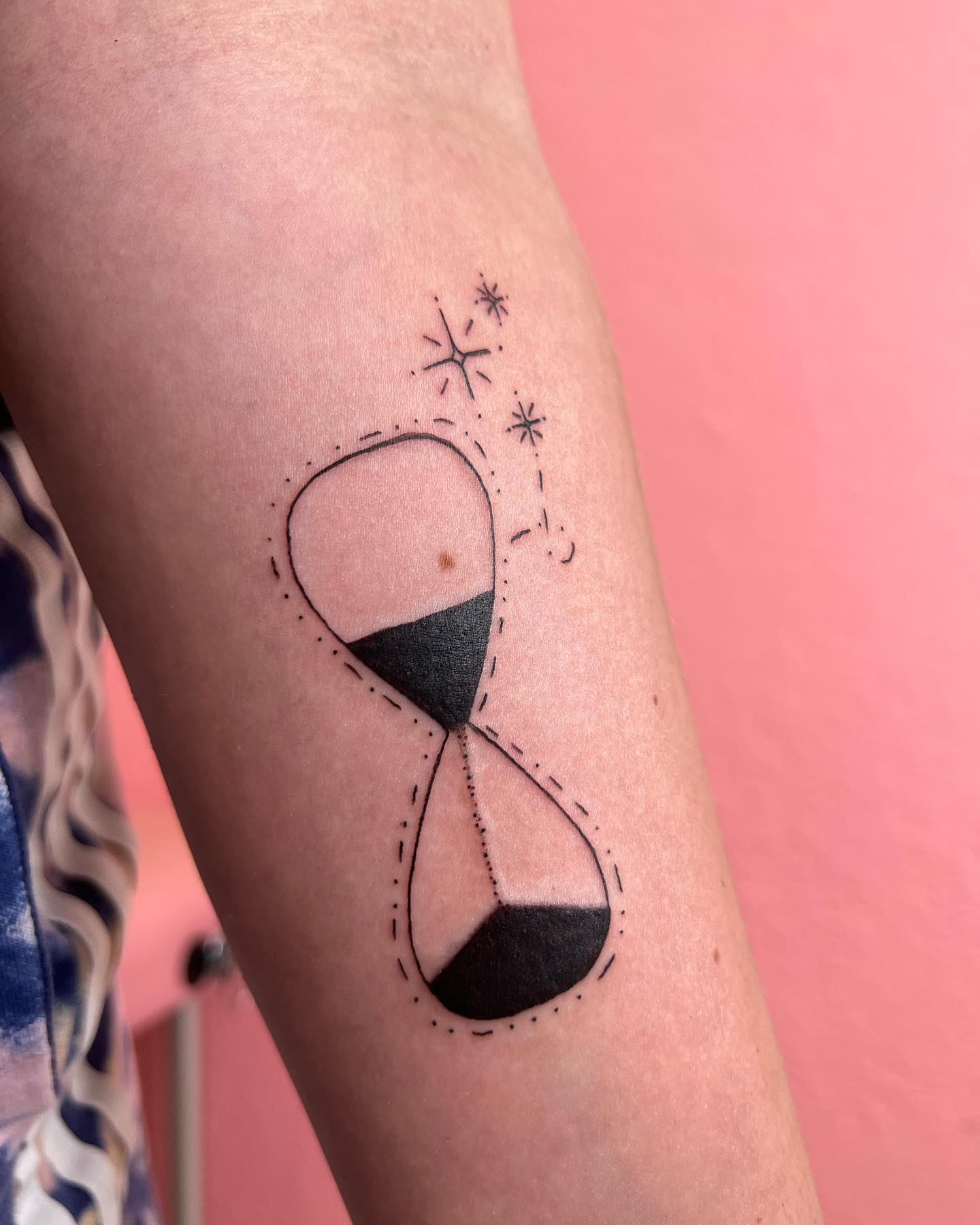 Pequeño tatuaje de reloj de arena en tinta negra