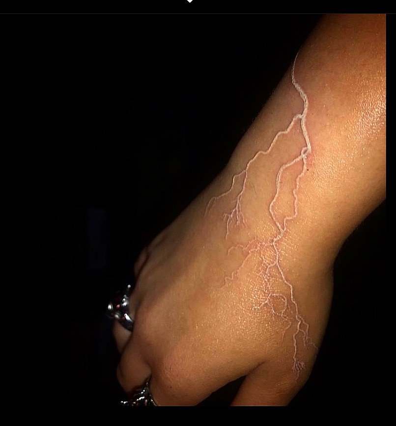 Tatuaje de relámpago de tinta blanca.