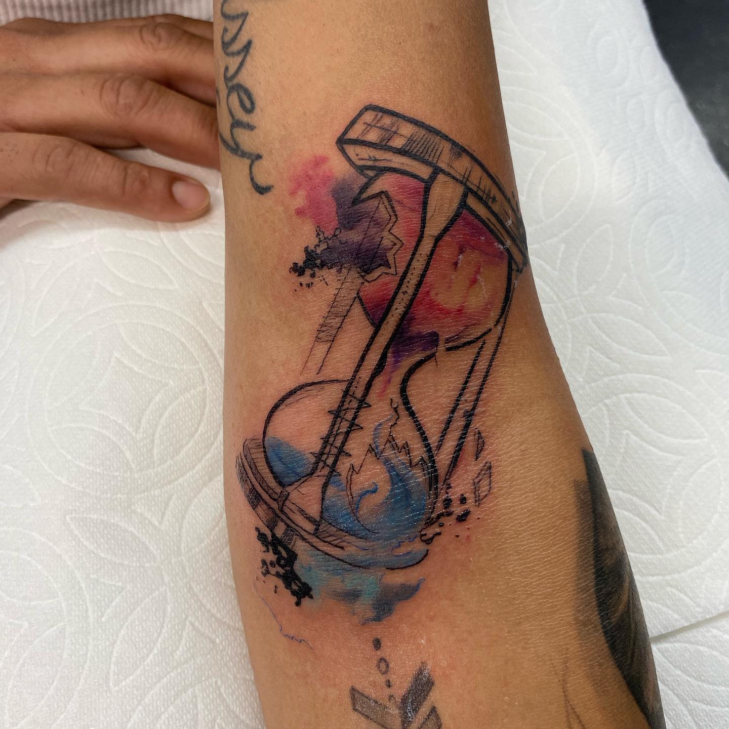 Tatuaje de reloj de arena artístico.