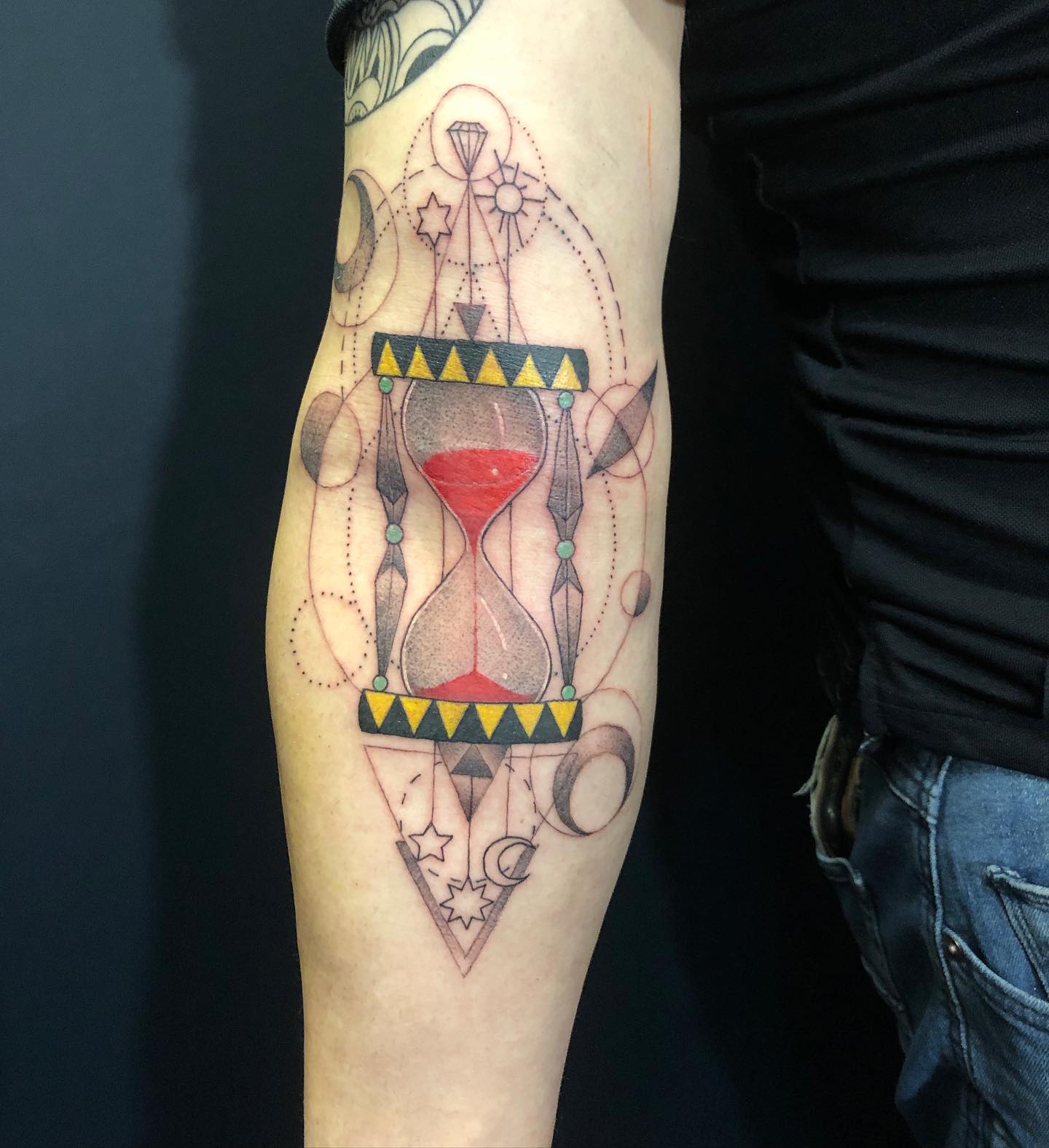 Tatuaje de reloj de arena en el antebrazo.