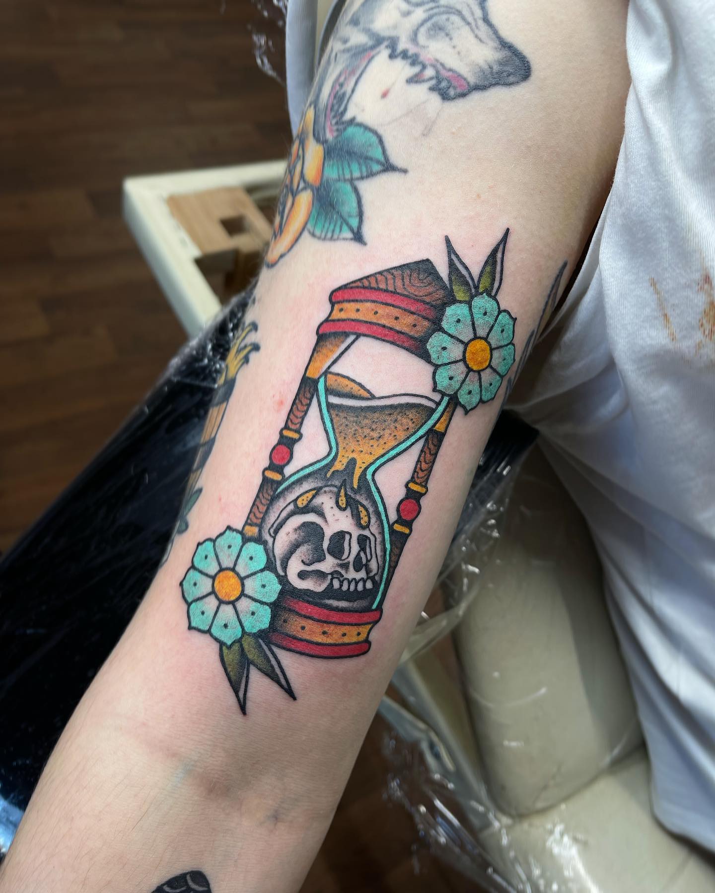 Tatuaje de reloj de arena en el brazo.