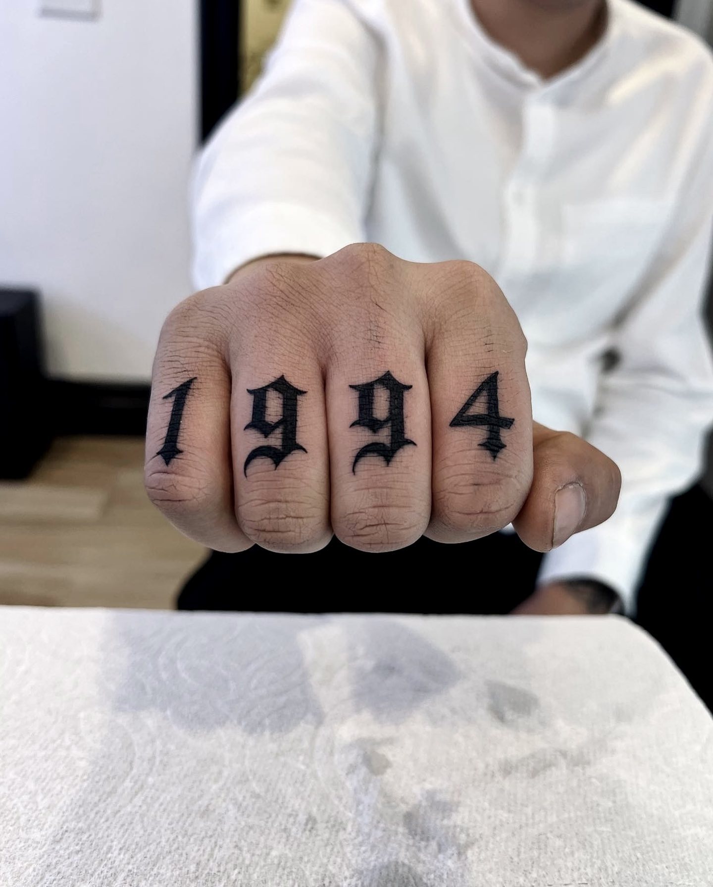 Número tatuado en los nudillos.
