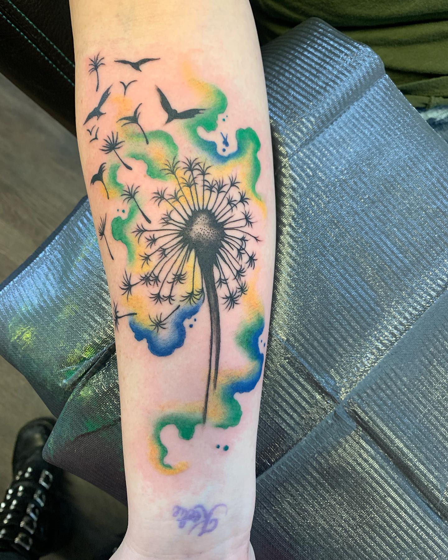 Tatuaje colorido de diente de león verde.