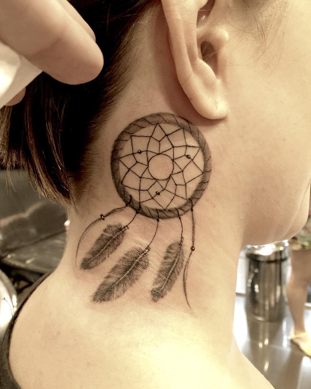 Tatuaje de atrapasueños detrás de la oreja