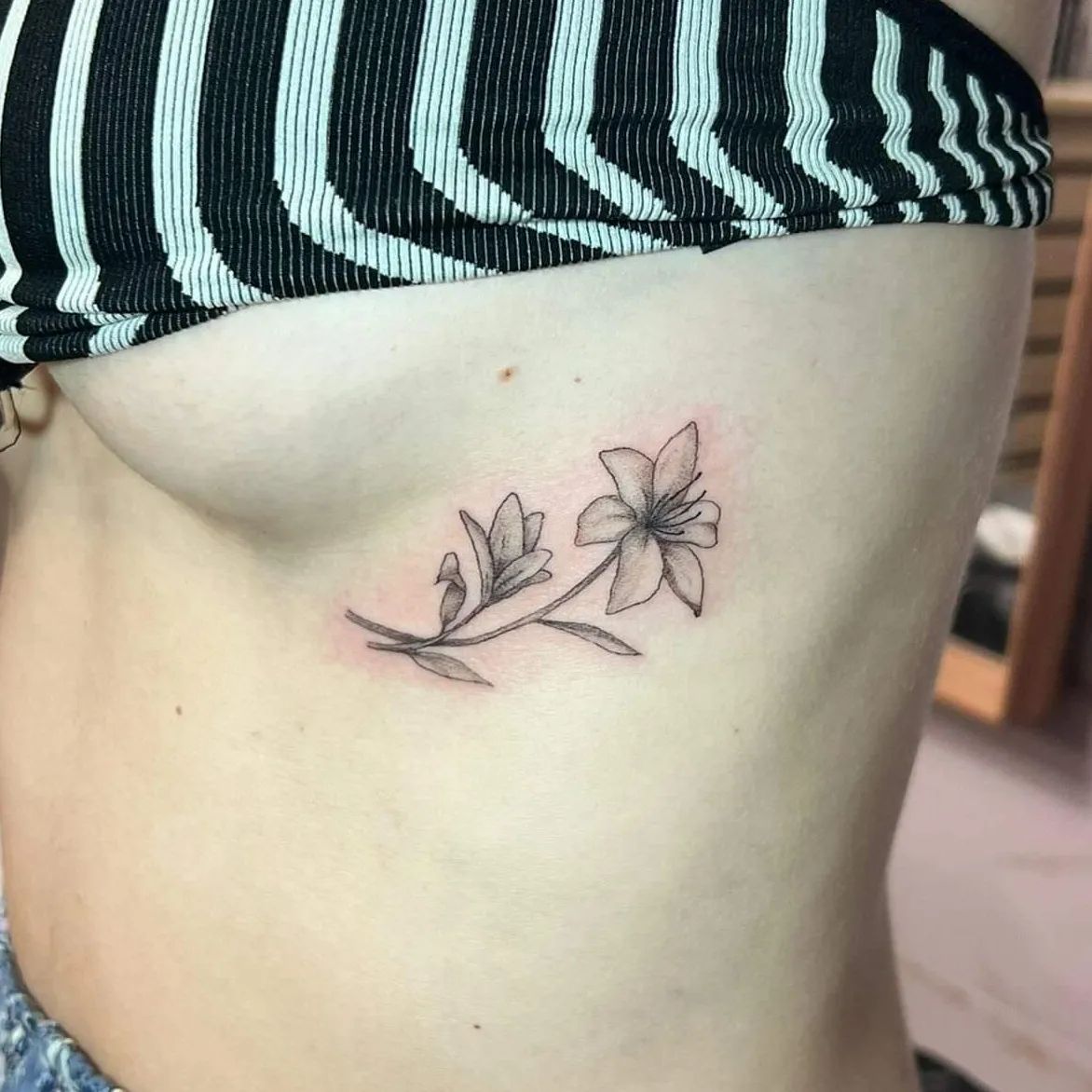 Tatuaje de lirio en la parte inferior del pecho.