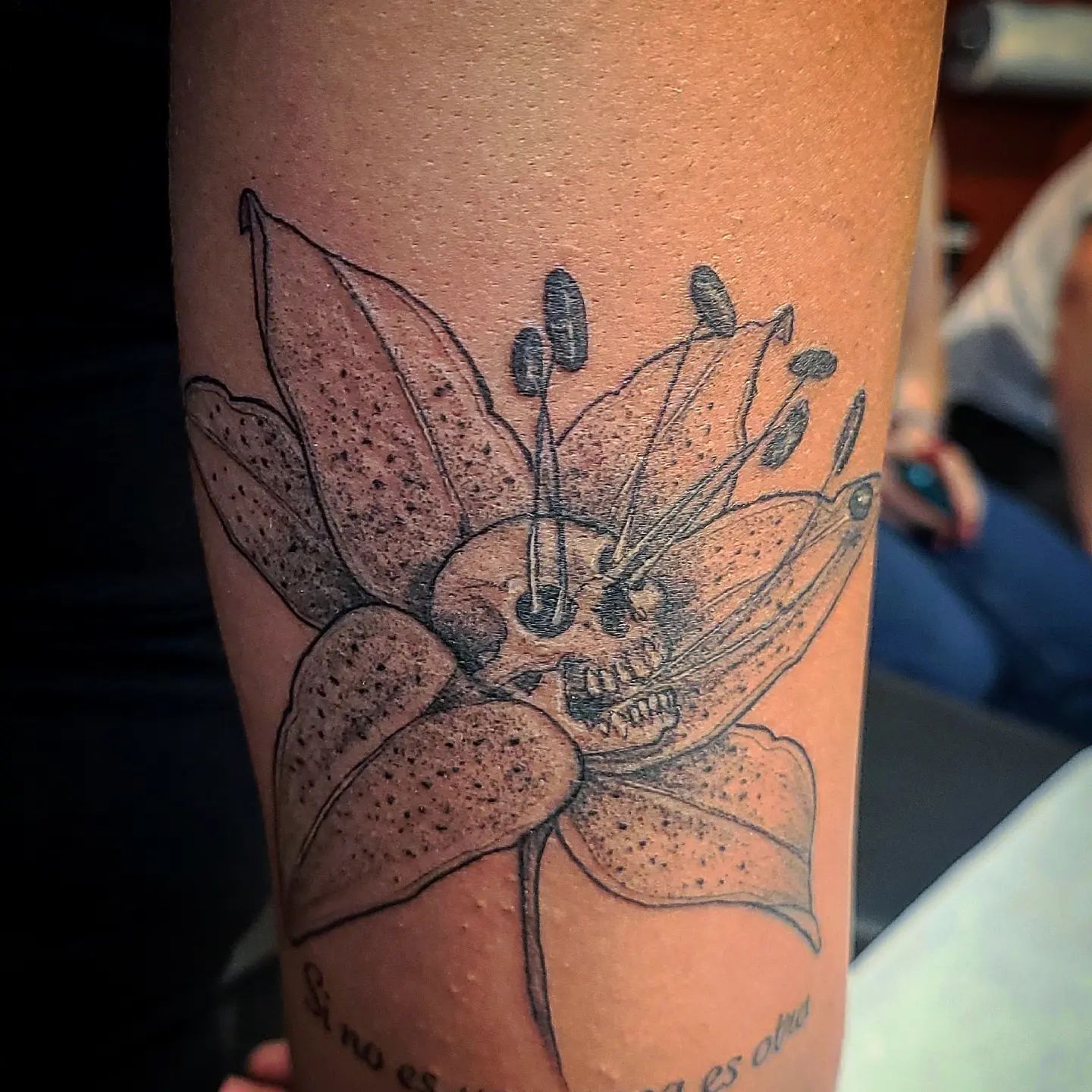 Tatuaje de Lirio y Cráneo en Trabajo de Tinta Negra