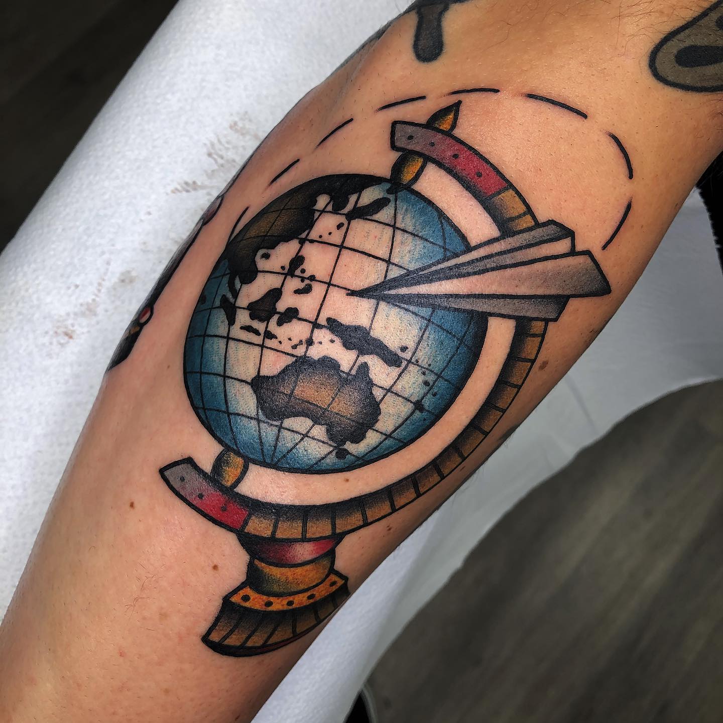 Avión de papel con tatuaje de pie colorido