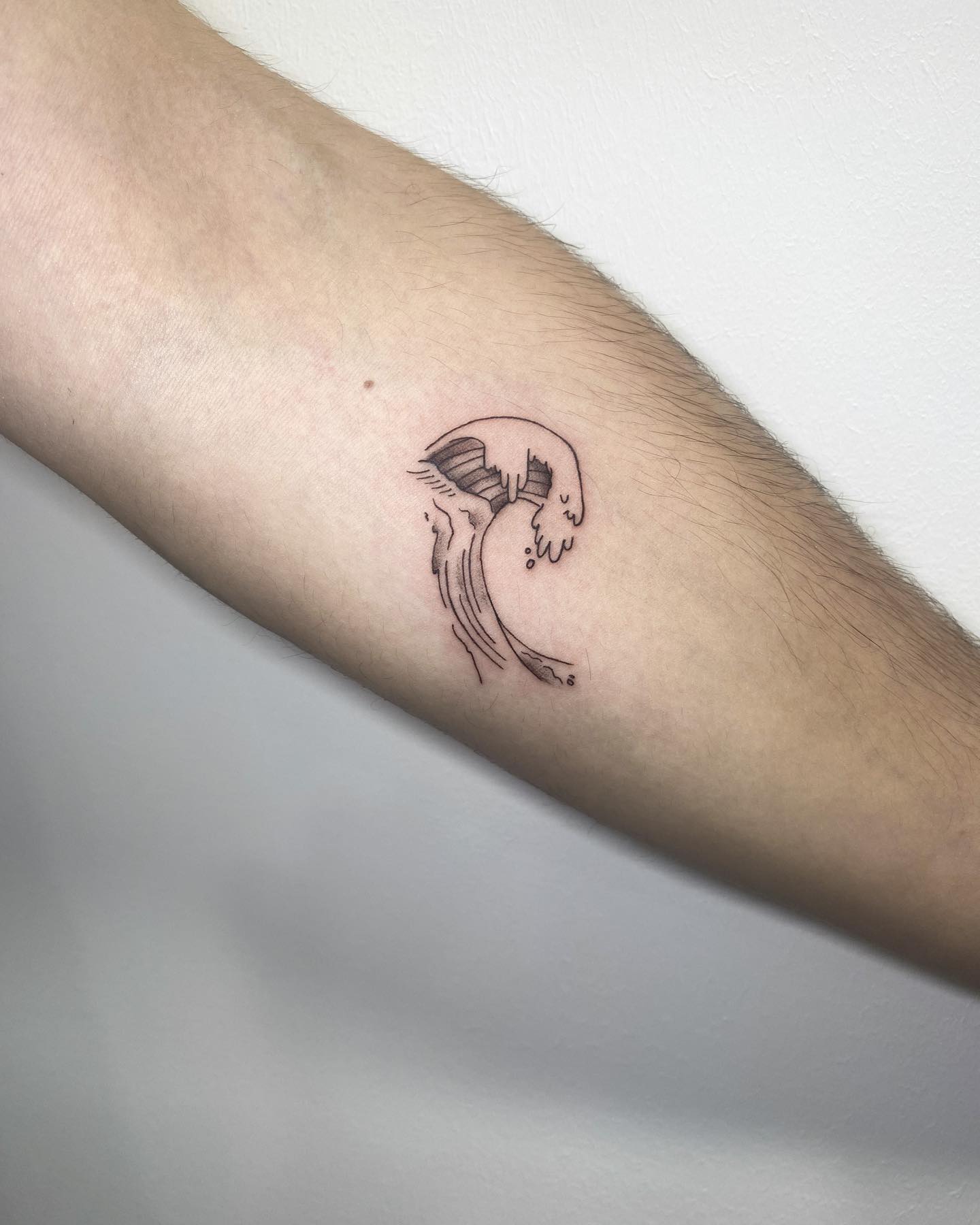 Pequeño tatuaje de una ola negra