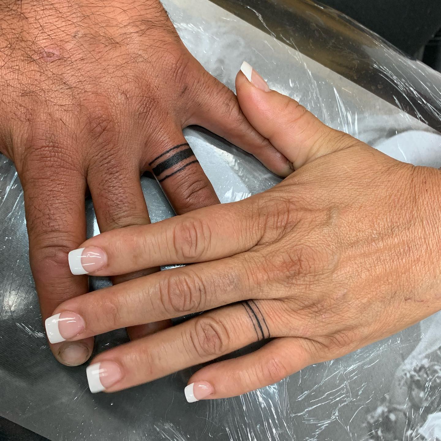 Tatuaje de anillo de bodas con contorno negro.