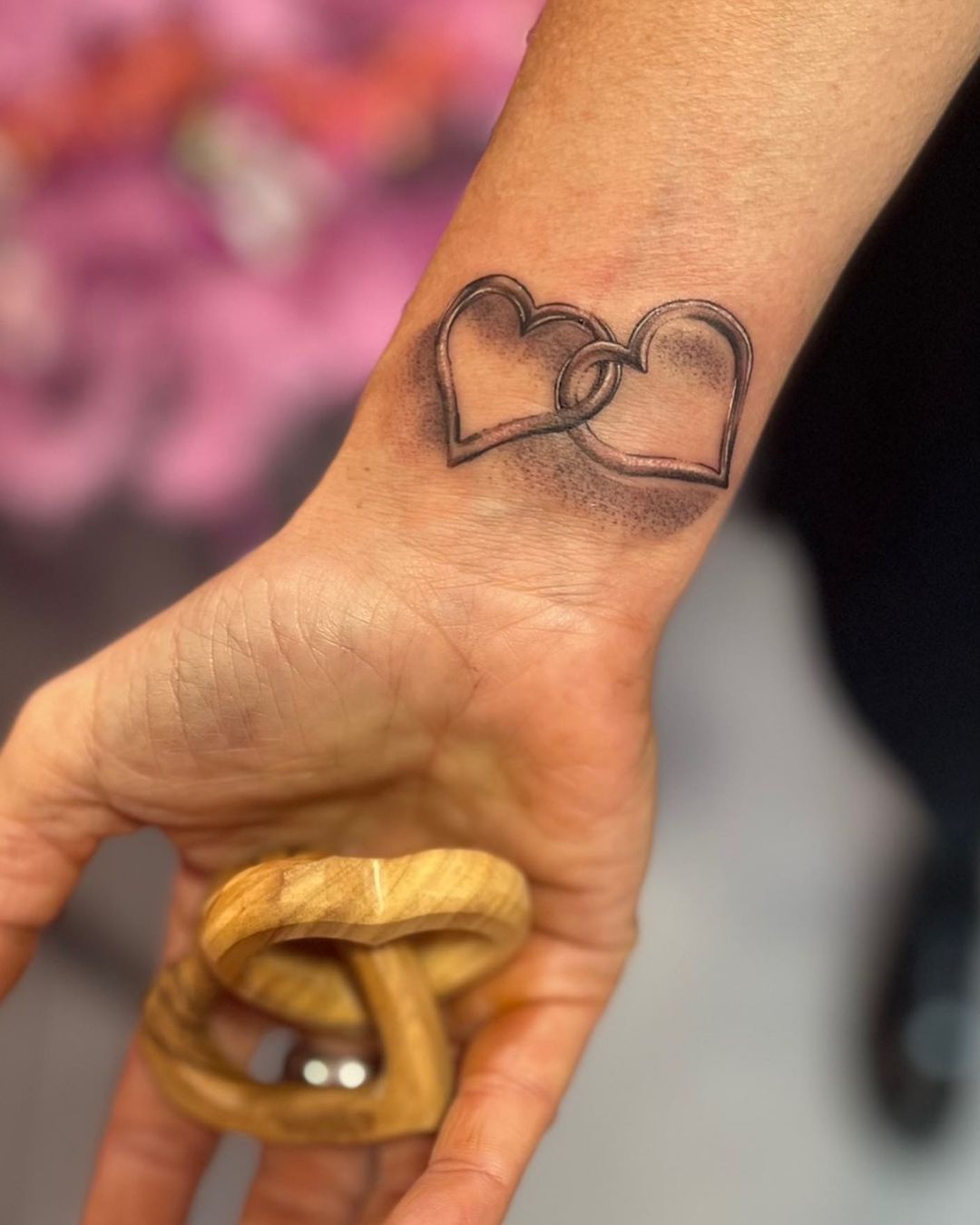 Tatuaje de corazón de pareja en la muñeca.