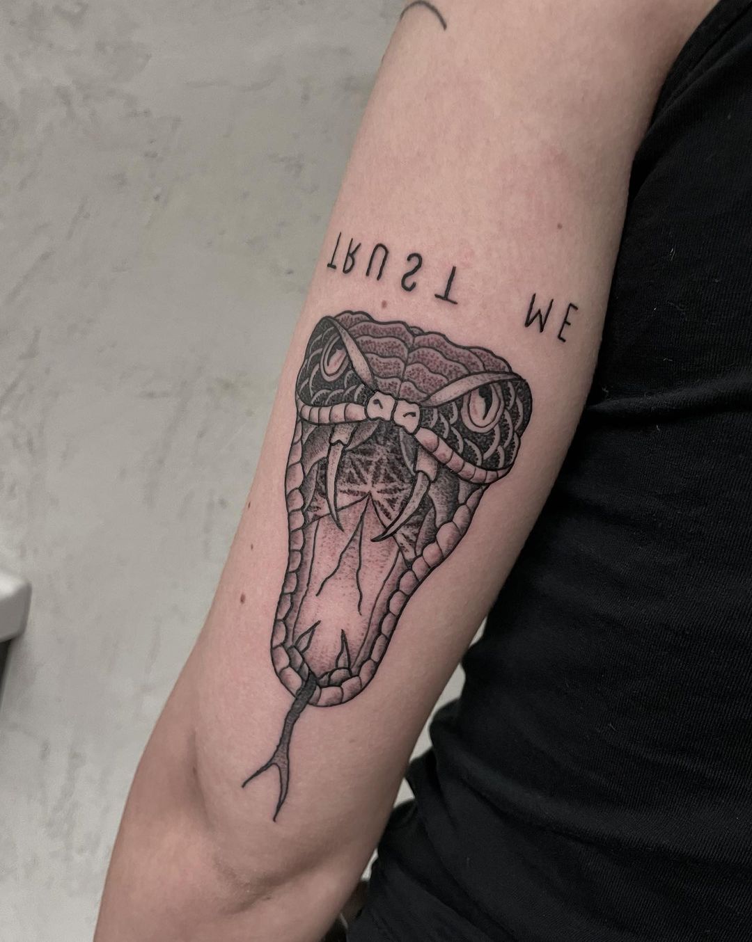 Tatuaje de serpiente colorida en el antebrazo.