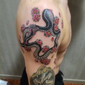 Tatuaje de Ouroboros colorido y artístico.