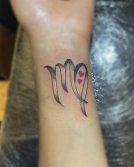 Tatuaje de Virgo en la muñeca.