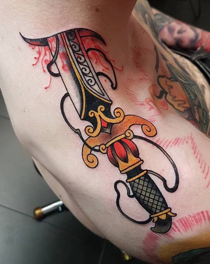 Un hombre con un tatuaje de daga Un hombre con un tatuaje de daga