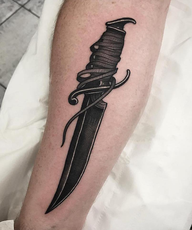 Persona con un tatuaje de daga Persona con un tatuaje de daga
