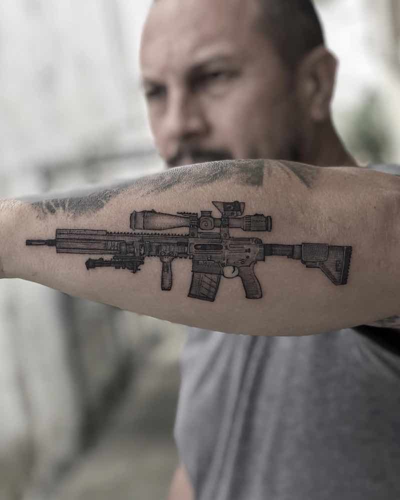 Hombre con tatuaje de pistola Hombre con tatuaje de pistola