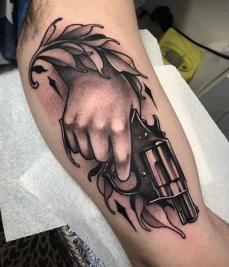 Persona con un tatuaje de pistola Persona con un tatuaje de pistola