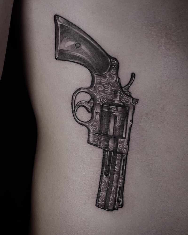 una persona con un tatuaje de pistola una persona con un tatuaje de pistola