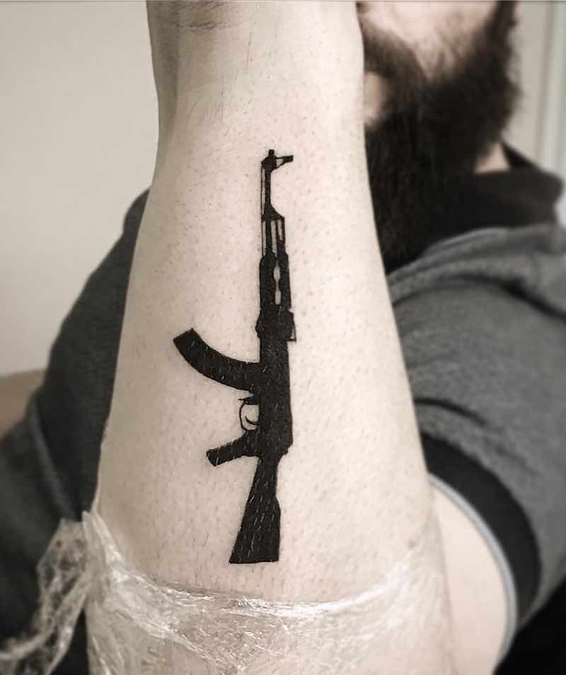 una persona con un tatuaje de pistola una persona con un tatuaje de pistola