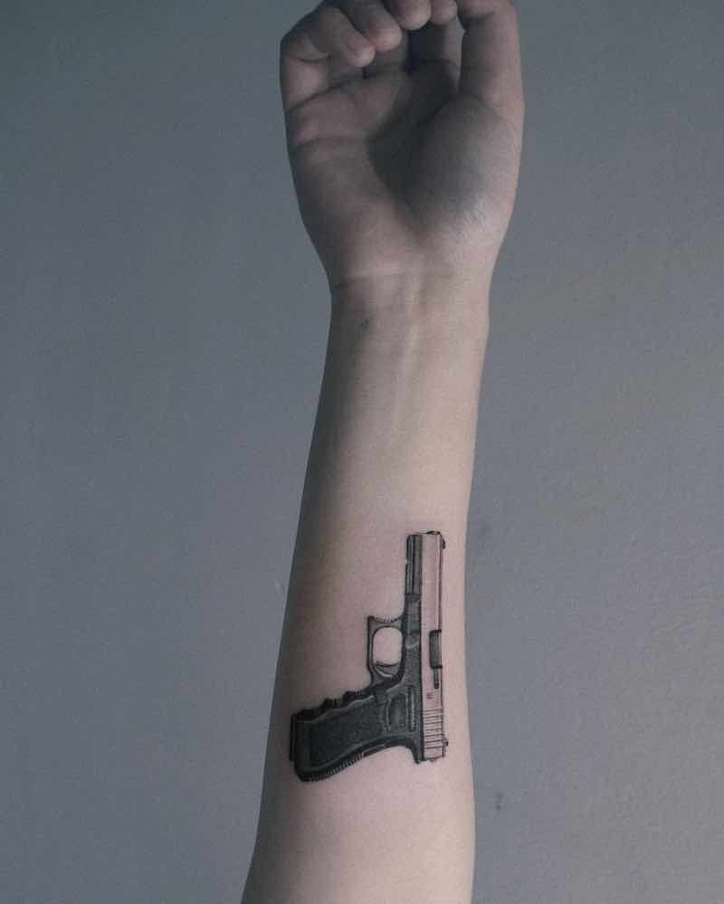una persona con un tatuaje de pistola una persona con un tatuaje de pistola