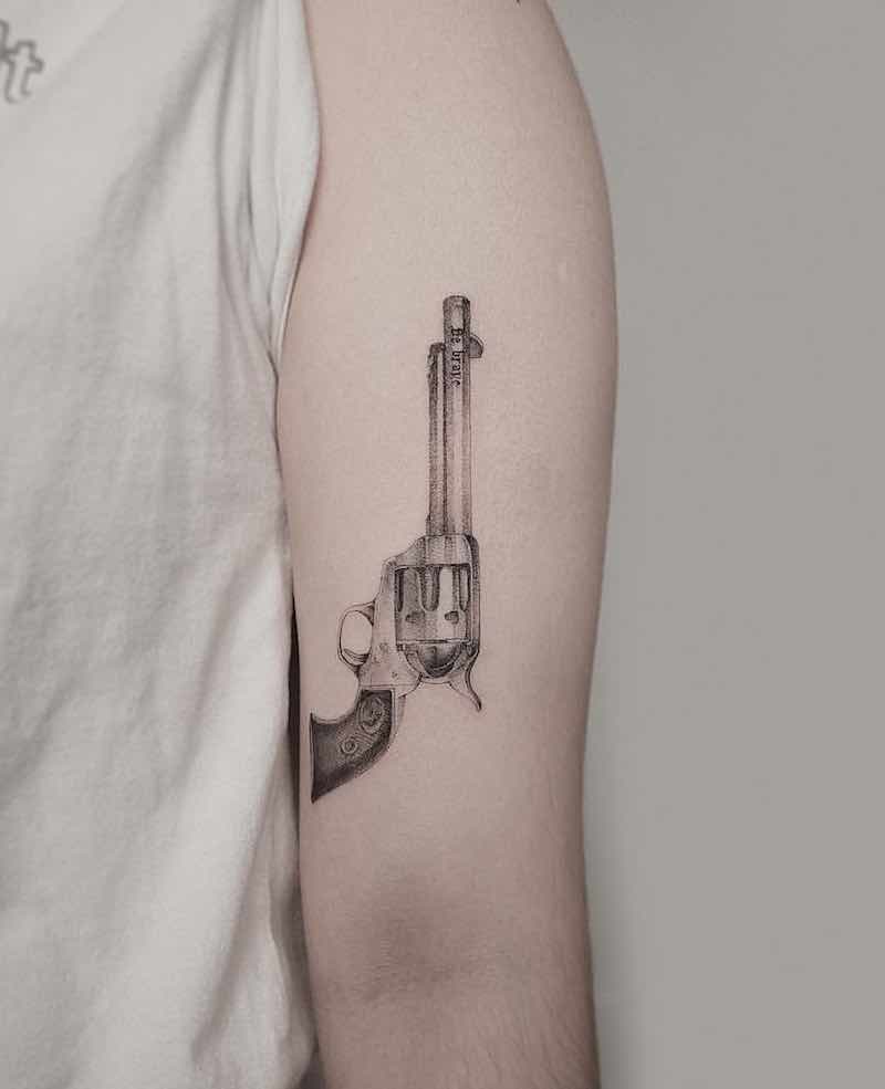 una persona con un tatuaje de pistola una persona con un tatuaje de pistola