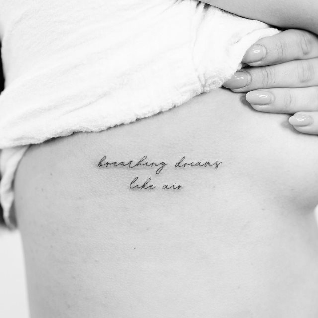 tattoo femenino de frase en las costillas 14