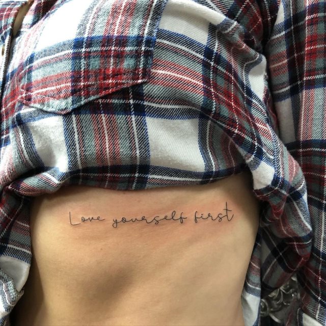 tattoo femenino de frase en las costillas 15