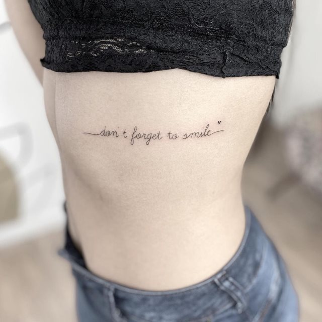 tattoo femenino de frase en las costillas 18