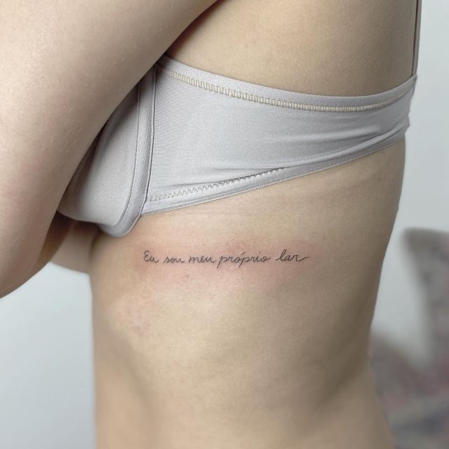 tattoo femenino de frase en las costillas 32