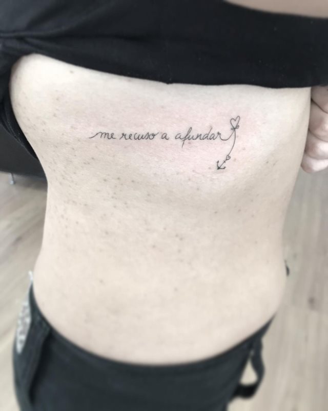 tattoo femenino de frase en las costillas 33