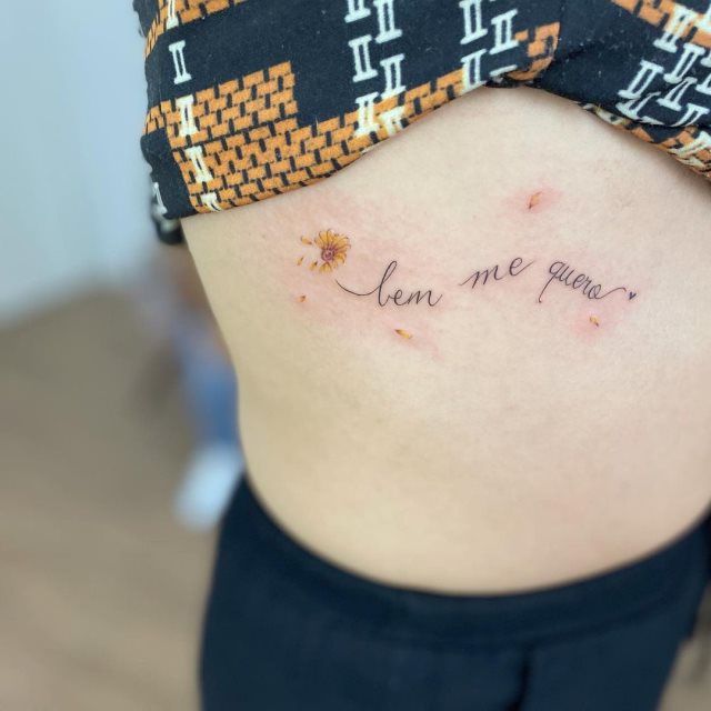 tattoo femenino de frase en las costillas 34