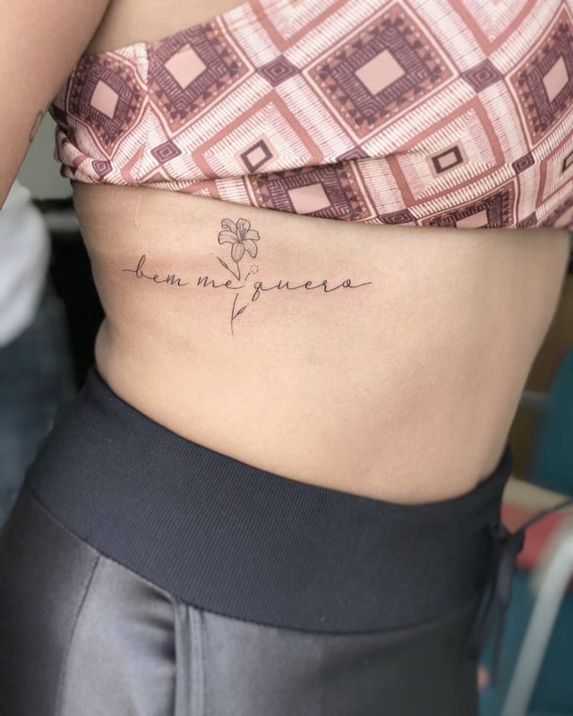 tattoo femenino de frase en las costillas 45
