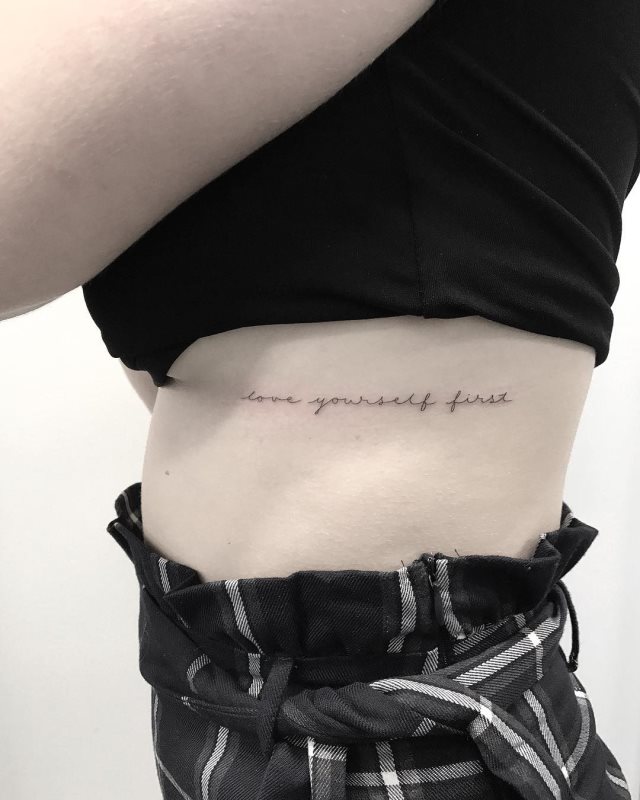 tattoo femenino de frase en las costillas 46