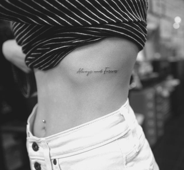 tattoo femenino de frase en las costillas 47