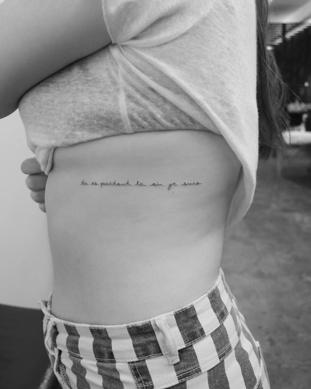 tattoo femenino de frase en las costillas 48