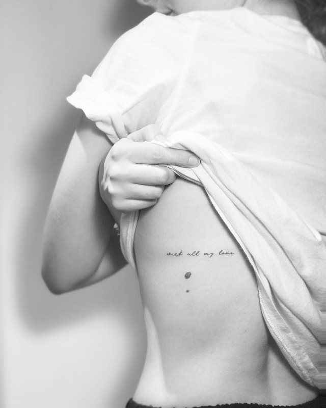 tattoo femenino de frase en las costillas 49