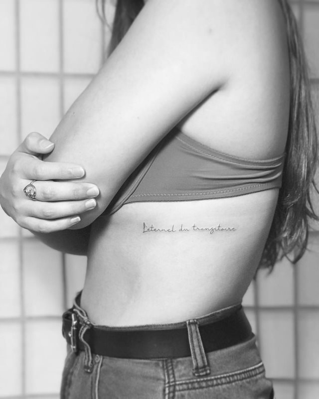tattoo femenino de frase en las costillas 50