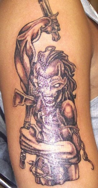 Ésta chica tiene un tattoo un poco extraño. Tiene un hacha en una mano y otra arma en la otra mano.