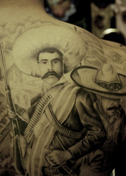 Espalda tatuada con un guerrillero. Muy bien hecho e impresionante.