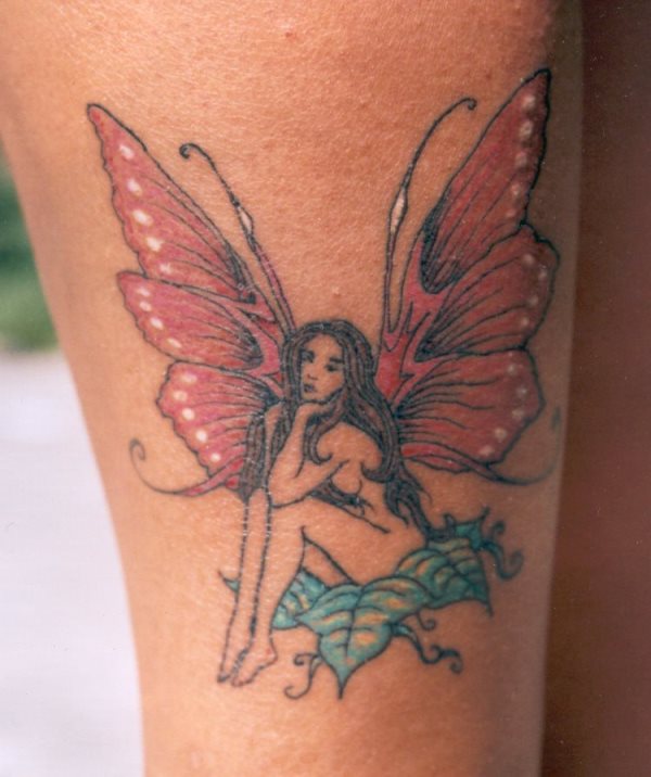 Hada con alas de mariposa desnuda, sentada sobre hojas en color turquesa Hada con alas de mariposa desnuda, sentada sobre hojas en color turquesa