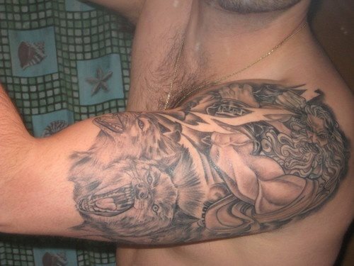 Este chico tiene en su brazo varios motivos y uno de ellos es un dios griego Este chico tiene en su brazo varios motivos y uno de ellos es un dios griego