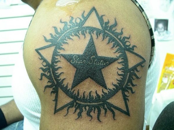 Un extrao diseo de una estrella en la que pone Star Status y que est rodeada por un sol del que salen rayos hacia adentro y hacia afuera y con puntas de estrellas tambin en la zona exterior Un extrao diseo de una estrella en la que pone Star Status y que est rodeada por un sol del que salen rayos hacia adentro y hacia afuera y con puntas de estrellas tambin en la zona exterior