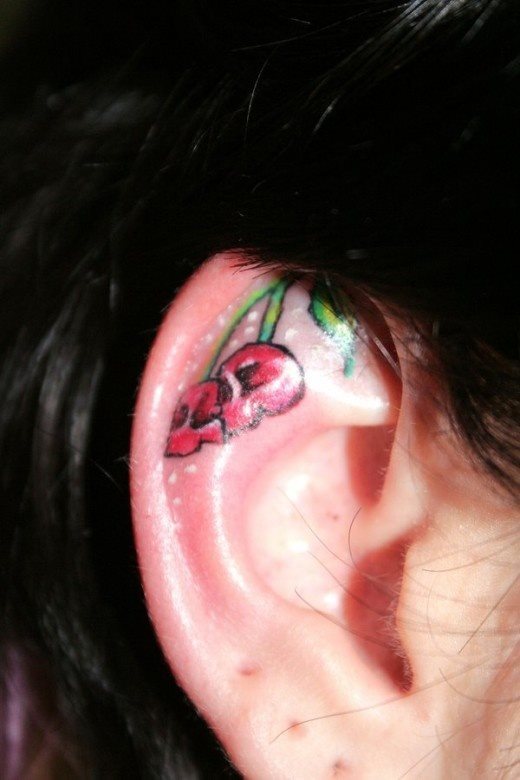 Diseo de unas cerezas rojas en la parte superior de la oreja Diseo de unas cerezas rojas en la parte superior de la oreja